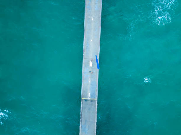 istock A blue sea water background with a white wave and pier 1490266852