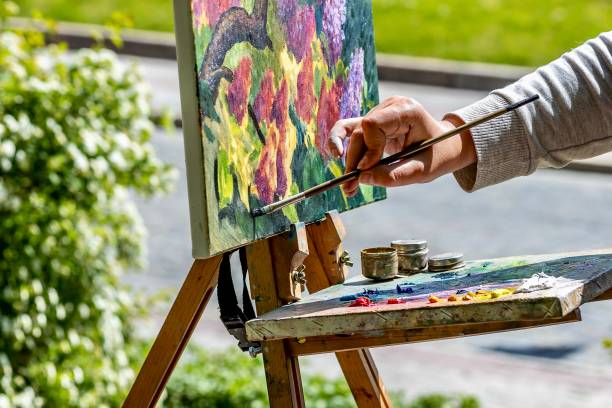 istock Hand with brushes painting a picture. 1490267155