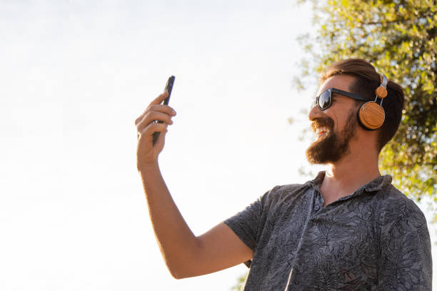 istock Young happy man taking selfie with mobile phone outdoors. Copy space. 1490273097