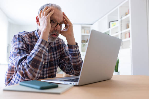 istock Stressed senior caucasian man working with laptop at home feeling overwhelmed. 1490273133