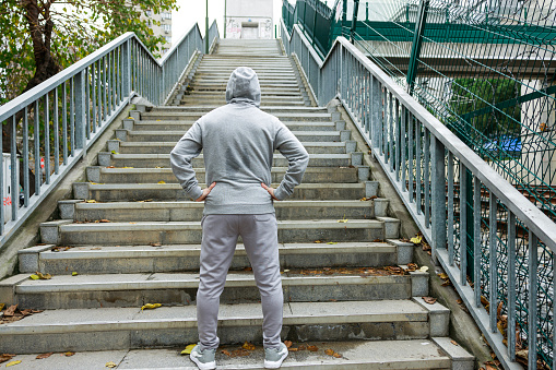 Young sporty man in sportswear preparing for stair run