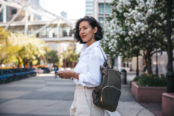 Geschäftsfrau beschäftigt mit Handy aus dem Büro, während sie auf den Bus wartet – Foto