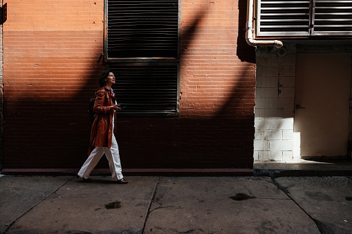 Morning in New York, a hispanic business person walks to the office.