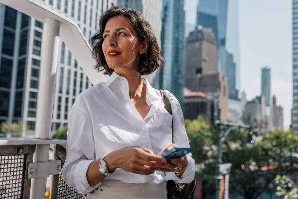 Business woman on break texting on mobile out of the office stock photo
