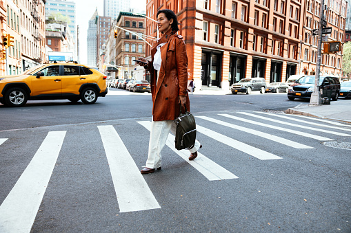 Business woman crossing the street to the office in the city downtown.