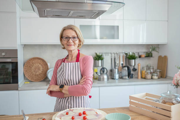 istock Senior woman in the kitchen is making pizza dough and mixing ingredients 1490279721