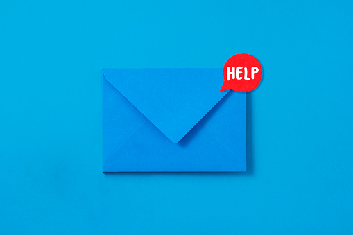 Blue envelope with help message attached on it on blue background