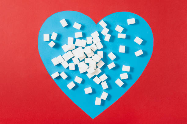 Sugar cubes in heart shaped paper on red and blue background