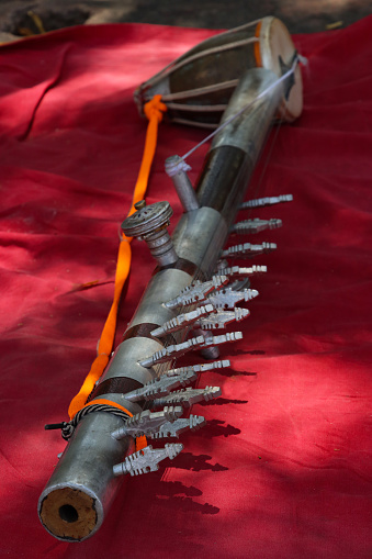 Stock photo showing close-up view of a ravanahatha an Indian folk bowed, stringed instrument left on red fabric.