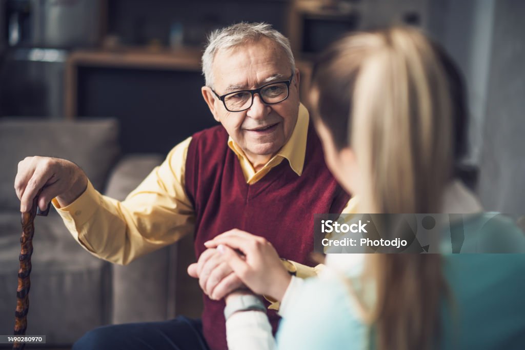 Home nurse caregiver Home doctor is visiting senior man to check his health. Professional caregiver is assisting old man at his home. Senior Adult Stock Photo
