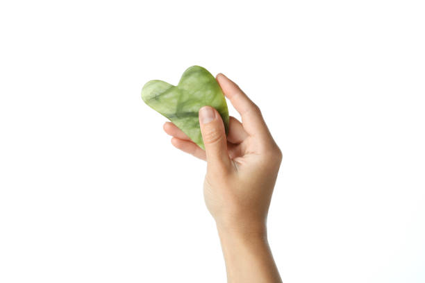 istock Female hand holds gua sha, isolated on white background 1490281106