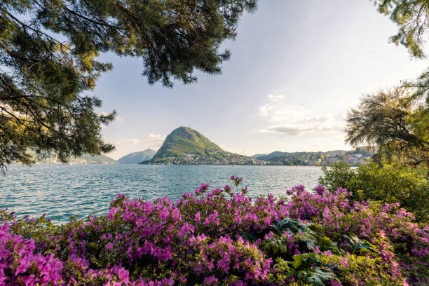 A beautiful scenery of the city skyline in different atmosphere.\nAmazing view of Lugano, Ticino cityscape at sunset, Switzerland