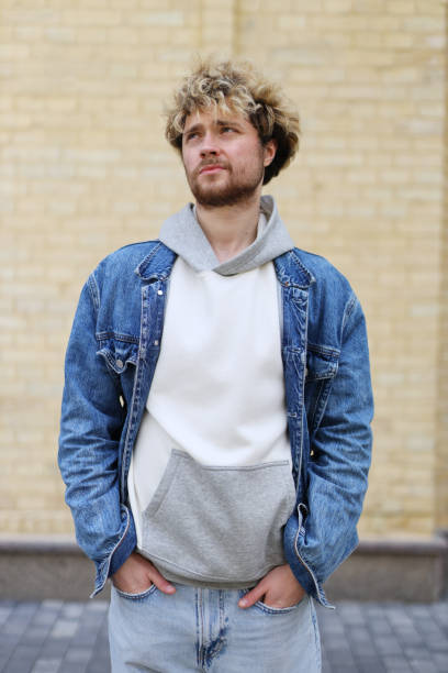 istock Doubting or dreaming young curly guy on the background of a brick wall. 1490284329