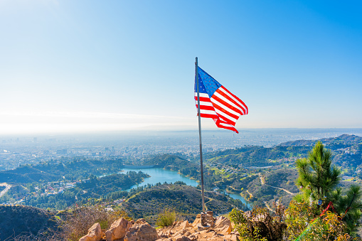 Wisdom Tree Hike at Griffith Park: Breathtaking view from the top of the Griffith Park Trail, with the iconic American flag, Santa Monica Mountains, glistening lake and the city of angels below.