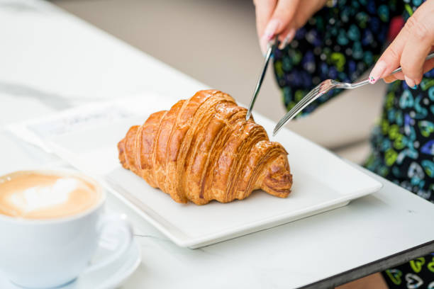 istock Croissant on a white porcelain plate with coffee on the side 1490286850