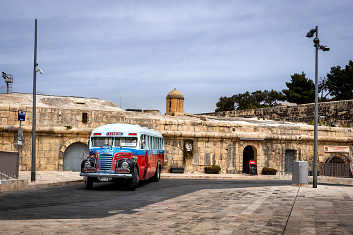Valletta, Malta - April 18, 2023: A vintage, red, white and blue maltese bus parked in downtown street.