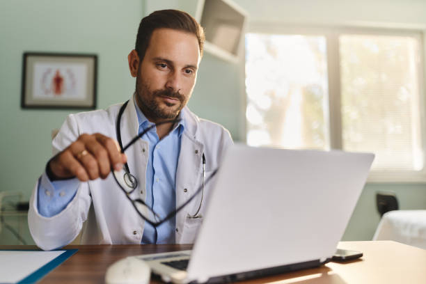 istock Young doctor reading an e-mail on laptop in the office. 1490287405