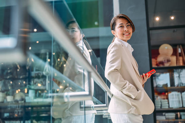 Juggling Devices and Responsibilities: A Day in the Life of an Asian Business Woman stock photo