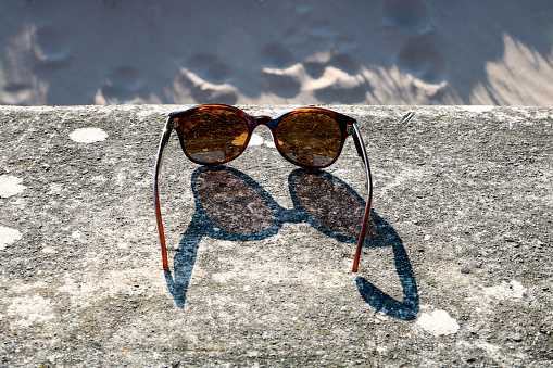 Sunglasses on a concrete seaside beach wall in evening spring sun