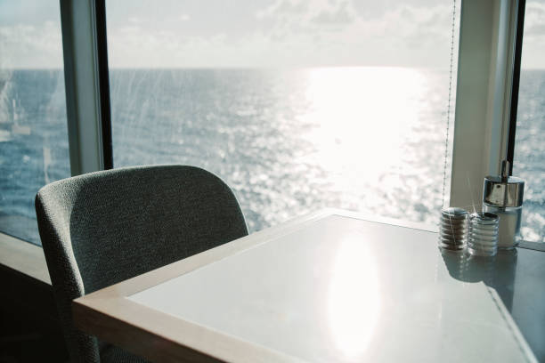 istock Salt and pepper shakers and sugar on an empty table by a large window with a sunny sea view. 1490288934
