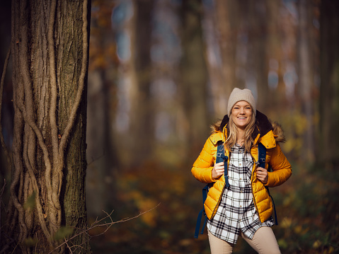 Happy female hiker enjoying in autumn day in nature and looking at camera. Photographed in medium format.