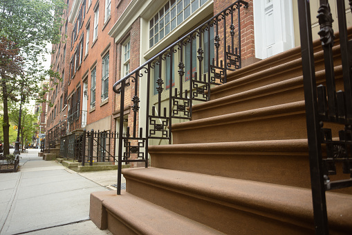 This photo showcases the distinctive architecture of West Village, highlighting a staircased entrance to a building. Explore the neighborhood's timeless charm and unique urban design.\nFun Fact: West Village is known for its beautiful historic townhouses, some of which date back to the early 19th century, preserving the neighborhood's rich architectural heritage.