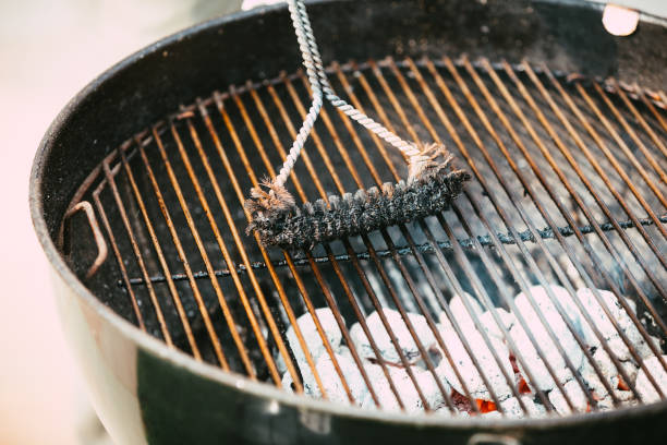 istock Man using brush to clean barbecue grill 1490290545