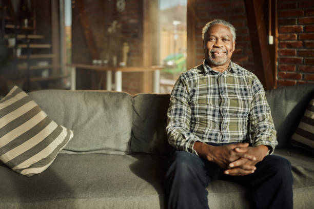 istock Smiling black senior man relaxing on sofa at home. 1490292541
