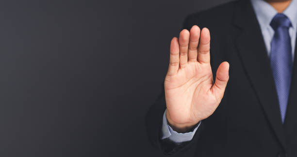 istock Businessman making stop gesture with his hands while standing on gray background. 1490294750