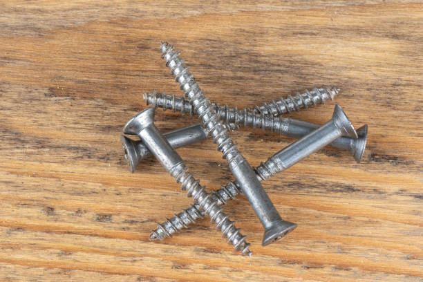 istock Several metal screws on a wooden background. 1490297099