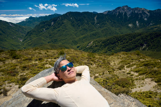 A mountain guide take a rest on the mountain top.