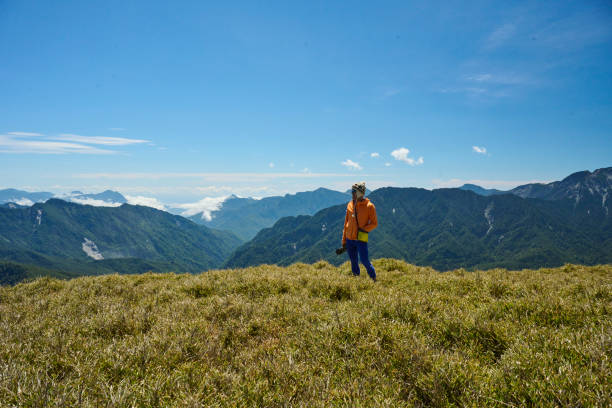 Hikers stand on top of a mountain looking at view.