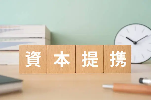 Wooden blocks with "shihonteikei" text of concept, pens, notebooks, and books.