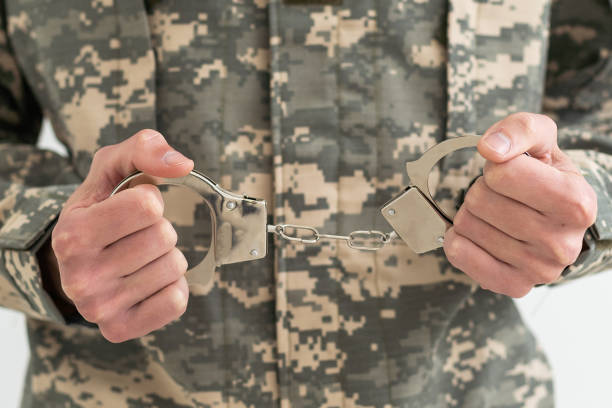 istock a military man is holding handcuffs 1490302519