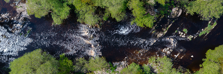 Drone view of a rural river in a remote location in Scotland on a bright spring morning