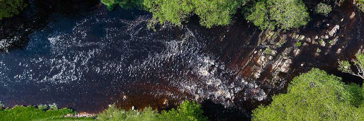 Aerial view from a drone of a Scottish river in a remote location on a bright spring morning
