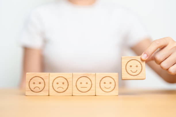 istock Hand choosing smile face from Emotion block for customer review, good experience, positive feedback, satisfaction, survey, evaluation, assessment, mood and world mental health day concept 1490304475