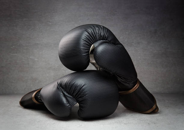 istock Pair of boxing gloves on concrete background in a dark environment 1490306049