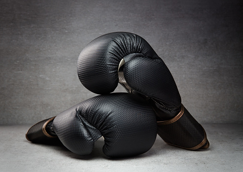 Pair of boxing gloves on concrete background in a dark environment