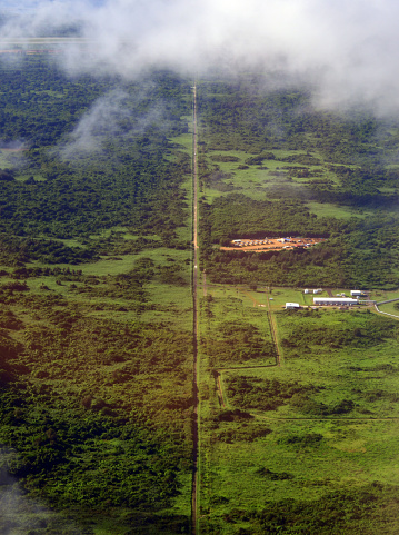 Tinian island, Northern Mariana Islands: view of Tinian from the air - looking south along 8th Avenue towards Tinian Airport (mostly covered by clouds) - on the right a military camp and the Tinian REKTS Relay Station, International Broadcasting Bureau (IBB).