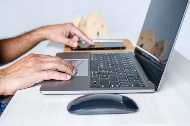 istock A man sits at a desk and is using a laptop computer. concept working from home, online, use of technology, online shopping, freelancing, internet. Selective focus, closeup, white blurred background. 1490309254
