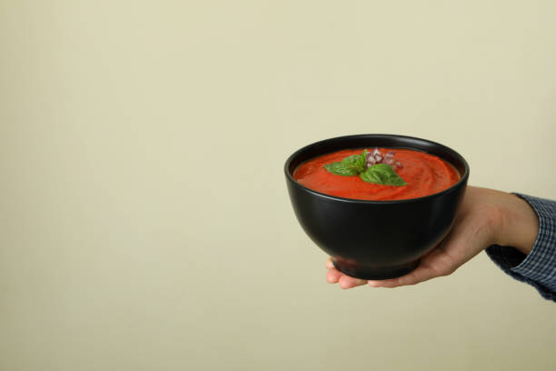 Female hand holds plate of tasty Gazpacho soup