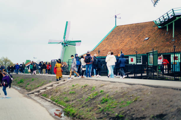 Zaanse Schans, The Netherlands-April, 21 2023: Tourists on the footpath at the windmills at Zaanse Schans, just north of Amsterdam.