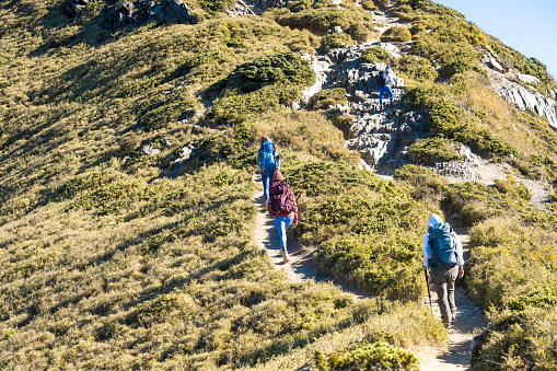 Hikers walking alone on top of a mountain.