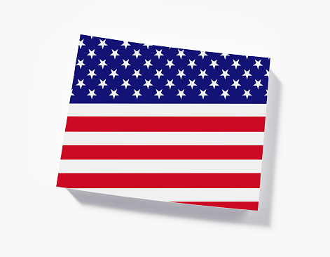 Beautiful American flag waving in the wind, with vibrant red white and blue colors against blue sky, with copy space.