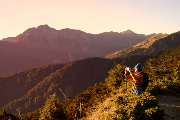 Mountain hiker taking photos on the mountain top.