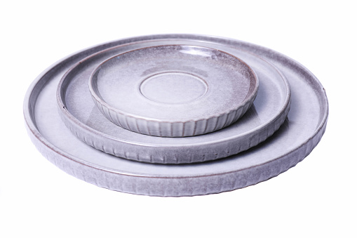 Set of gray ceramic round plates isolated on white background.