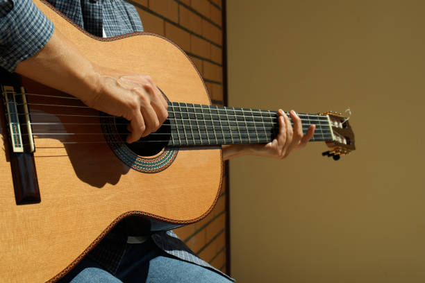 istock Woman in shirt playing on classical guitar 1490320026