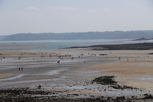 On April 20th 2023, In Saint Quay Portrieux, Brittany, France, during spring holidays and large tides, people and tourist enjoy walk fishing, sailing, swimming, surfing