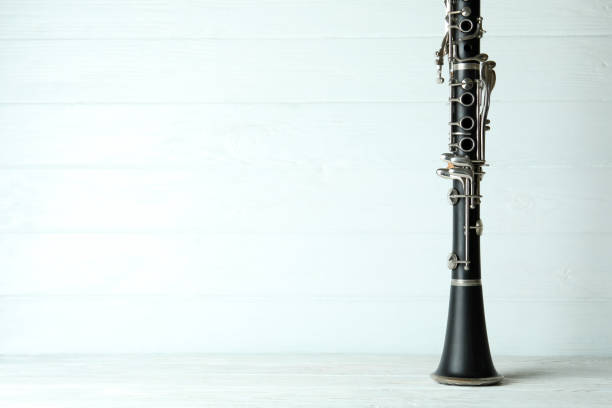 Clarinet on white wooden background, space for text.